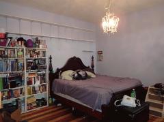 Front second floor bedroom with wood floors, fireplace (inoperable) and ceiling fan/light combination.