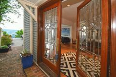 1116 Carney Street has an east side covered entryway with beautiful double glass paned doors. The walkway is lined with bricks along the side to the tiered deck.