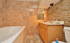 A full bathroom with tub and large vanity will accommodate the lower level Master Bedroom. Notice the exposed wall.