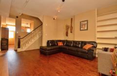 The welcoming Living Room boasts an open and airy feeling with its high ceilings and floor to ceiling built-in bookcase. Furnished with a wrap-around leather couch and a cozy chair, all you need to do is fill the bookcase with books, pictures and other special mementos.