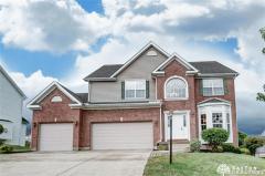 Front view of home showing brick and 3-car garage.