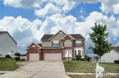 Front view of home showing brick and 3-car garage. Notice the full length driveway from all three bays.