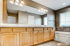 Luxury master bathroom with dual sink vanity, ceramic floor, and whirlpool tub.