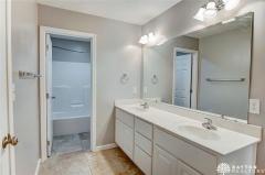Second floor hall bath with dual sink vanity and ceramic floor.