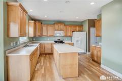 Large kitchen with 42 inch cabinets and 9 foot ceiling. The door to the far right is a large pantry. Notice the hardwood floor, island and recessed lighting. Refrigerator stays.