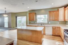 Large kitchen with 42 inch cabinets and 9 foot ceiling. Notice the hardwood floor, island and recessed lighting. To the left is the breakfast nook area, great room, and sliding door to the deck.
