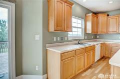 Large kitchen with 42 inch cabinets and 9 foot ceiling. Notice the hardwood floor and recessed lighting.