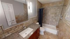 Updated guest bathroom has Travertine tiles.