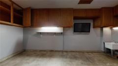 Garage with custom storage, TV plus hot and cold water.