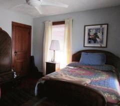 Bedroom offers ceiling fan & beautiful wood trim around windows and door.