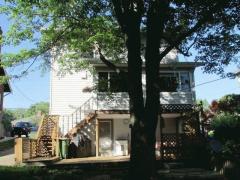 Rear view of house with 3 seasons room and a deck. The walk out from the lower level is perfect for entertaining family and friends.