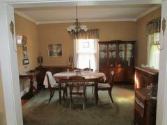 Dining room offers hardwood floors, windows, crown molding, and neutral walls.