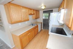Kitchen equipped with smooth top stove, over-the-range microwave, dishwasher, and refrigerator