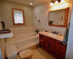 Luxurious Master Bath w/Jetted Tub, Ceramic tile, Beautiful wood cabinetry & stunning light fixtures!