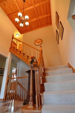 Stunning wood-beam ceiling, chandelier, natural woodwork & railings highlight the room as you enter! What an Entrance!