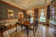 The formal dining room has double moldings with custom drapes, with pella windows to floor with hand painted ceiling and hardwood floors.
