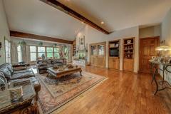 The Great Room is large with lot of windows with custom drapes and wet bar, refrigerator, built in bookshelves.