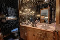 The powder room as custom drapes with hardwood floors.