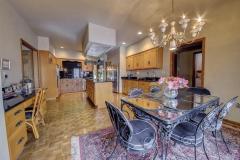 The updated gourmet kitchen features granite counter tops wood floors, desk, thermador gas grill, Jenn-air cooktop, stainless steel refrigerator, stainless steel microwave & oven maytag dishwasher, chandelier and French doors that open to the patio.