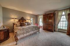 Master Bedroom has custom drapes, transom above windows ,and carpet.