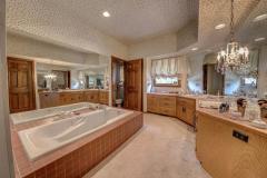 The master bathroom has double sinks, and large tub, and tiled area where shower and commode are located.