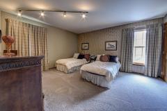 This bedroom has custom drapes with matching wallpaper on one wall.