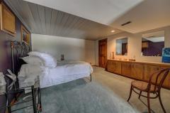The fifth bedroom is located in the lower level with walk in closet and carpet that opens into sitting room with double doors.