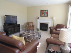 Large family room complete with fireplace and newer carpet.