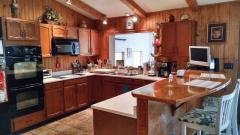 Country Kitchen with newer double counters, newer appliances, except trash compactor, and opens to solarium.