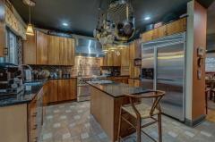 Cherry cabinets, stainless appliances, granite counter tops, glass tile back splash, hanging pot rack, 2 ovens under, stainless hood, kitchen sink with disposal and prep sink.