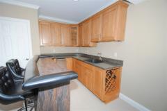 Wet bar has commercial ice maker and wine rack