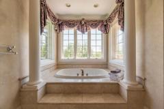 Jetted tub surrounded by windows offering natural light! Get in and Relax!