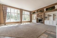 Family room with built in shelving, Fireplace, wall to wall carpet, open concept, natural lighting and easy access to outside!