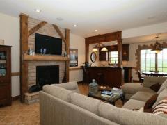 Lower level bar area with family room and rustic fireplace.