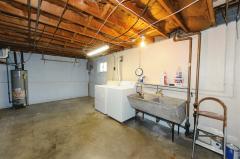 Laundry Area in 2 car tandem garage with XL double sink.