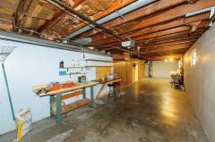 Work bench in tandem garage with HVAC & Hot Water Heater in rear on left.