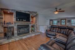 Open living room boasts custom stone wood burning fireplace with built in entertainment center.