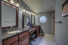 Master bathroom with double vanity, granite countertop, and ceramic tile.