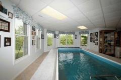 You'll love this sparkling indoor pool surrounded by ceramic tile. Great for entertaining or exercising. It is approximately 5 ft deep and has a retractable cover.