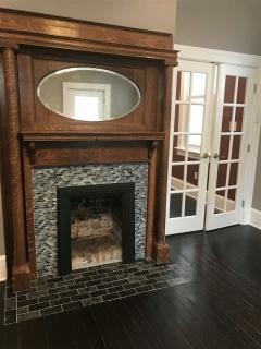 LIVING ROOM HAS A BEAUTIFUL FIREPLACE.