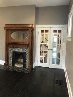 LIVING ROOM HAS WOOD FLOORS, FIREPLACE, AND FRENCH DOORS INTO THE DINNING ROOM