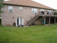 REAR VIEW*FULL BRICK WRAP*MAINTENANCE FREE EXTERIOR*DECK WITH ALUMINUM & WOOD RAILING*RAISED PLANT BEDS*WHITE PINE TREES IN REAR YARD IS THE LOT LINE