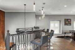 Overlooking the floating staircase, this modern glass bar is architecturally stunning!
