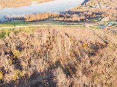 View from back of property showing paved subdivision road and powers lines as property line.