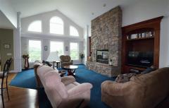 Wall of windows looking at the great view of the valley. Stone wbfp. Carpetned area. Cathedral ceiling
