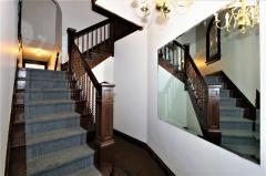 Grand turned staircase (which also goes down on the other side to 2nd basement access and to outside). There is a lovely stained glass window at the landing!
