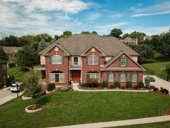 Red Brick/stone exterior finish with green shutters accenting this beautiful basically maintenance free exterior.
